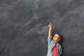 Casual little girl showing finger up at gray background Royalty Free Stock Photo