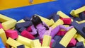 Little girl in a pool with toy cubes in a game center