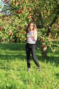 Girl under apple tree holding apple Royalty Free Stock Photo