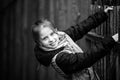 Little girl portrait near the fence in the village. Black and white photography. Royalty Free Stock Photo