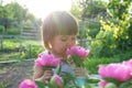Little girl portrait with peony flower at summer