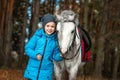 Little girl portrait, stands next to a white pony close-up on the background of nature. Jockey, epodrome, horseback riding Royalty Free Stock Photo