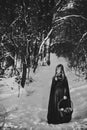 The little girl poses in the winter forest. Fairytale black and white.