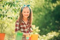 Little girl Potted. Garden tools. Child Farmer planting in the vegetable garden. Carefree childhood.