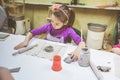 Little Girl At Pottery Workshop Working With Clay