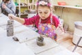 Little Girl At Pottery Workshop Working With Clay