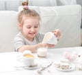 Little girl pouring milk into her teacup Royalty Free Stock Photo