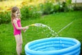 Little girl pouring water into a pool Royalty Free Stock Photo