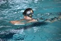 Little girl practicing flutter kick with kick board in indoor swimming pool Royalty Free Stock Photo