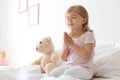 Little girl praying in bed at home. Space Royalty Free Stock Photo