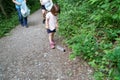 Little girl, pregnant mother and grandmother cleaning the forest of plastics