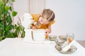 little girl prepares dough or cream in a submersible mixer and licks the whisk.