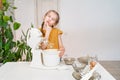 little girl prepares dough in a submersible mixer and licks his fingers