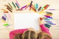 Little girl prepares to paint on a blank sheet of paper. Drawing is done by a child with colored pencils or felt-tip pens. Royalty Free Stock Photo