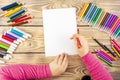 Little girl prepares to paint on a blank sheet of paper. Drawing is done by a child with colored pencils or felt-tip pens. Royalty Free Stock Photo