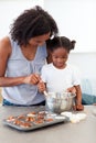 Little girl preparing biscuits with her mother