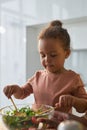 Little girl preparing salad in the kitchen Royalty Free Stock Photo