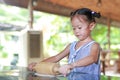 Little girl process of preparation homemade pizza. Child using Wooden rolling pin on Dough