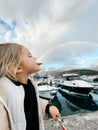 Little girl in profile posing holding a rainbow on her tongue