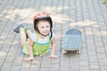 Little girl in protective helmet lies on park path Royalty Free Stock Photo
