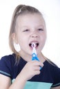 Little girl pull out a tooth with toy pliers on a white background