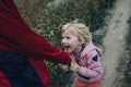 A little girl pulls her brother& x27;s sleeve while walking in nature. A happy child plays with his family in the fresh Royalty Free Stock Photo