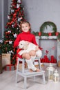A little girl with a puppy Golden Retriever on a background of Christmas tree Royalty Free Stock Photo
