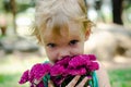 Little girl with purple flowers bouquet looking at camera Royalty Free Stock Photo