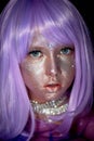 A little girl in a purple wig with silver sequins on her face. An alien, fantasy world.A fairy or an alien.