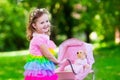 Little girl pushing a toy stoller wth doll Royalty Free Stock Photo