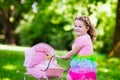 Little girl pushing a toy stroller wth doll Royalty Free Stock Photo