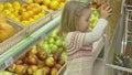 Little girl puts fruits in the trolley Royalty Free Stock Photo