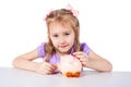 A little girl is putting coins into a pig piggy bank Royalty Free Stock Photo