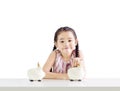 Little girl putting money on a piggy bank.Thinking about saving Royalty Free Stock Photo