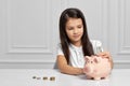 Little child girl with piggy bank at home Royalty Free Stock Photo