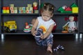 Little girl putting on socks sitting on floor indoor Royalty Free Stock Photo