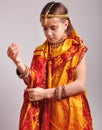 Little girl putting on traditional Indian clothing and jeweleries