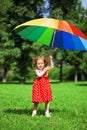 Little girl with a rainbow umbrella in park Royalty Free Stock Photo