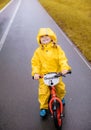 Little girl in rainy day on bike in a park Royalty Free Stock Photo