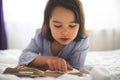 Little girl reading from bible while she is in bed in the morning Royalty Free Stock Photo