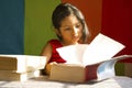 Little girl reading big books as if she is a scholar, Pune, Maharashtra, India.