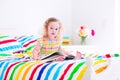 Little girl reading a book in bed Royalty Free Stock Photo