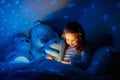 Little girl reading a book in bed Royalty Free Stock Photo