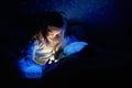 Little girl reading a book in bed Royalty Free Stock Photo