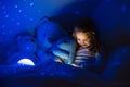 Little girl reading a book in bed Royalty Free Stock Photo