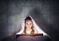 Little girl reading book in bed Royalty Free Stock Photo