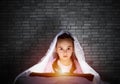 Little girl reading book in bed Royalty Free Stock Photo