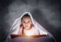Little girl reading book in bed Royalty Free Stock Photo