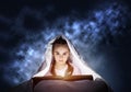 Little girl reading book in bed Royalty Free Stock Photo