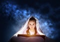 Little girl reading book in bed Royalty Free Stock Photo